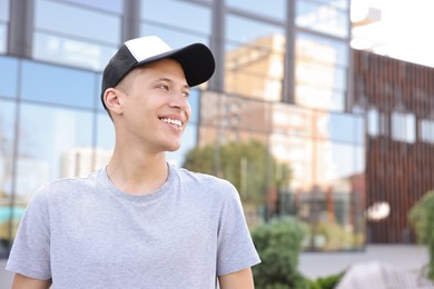 Portrait of smiling man in baseball cap outdoors. Space for text