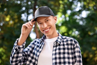 Photo of Portrait of smiling man in baseball cap outdoors