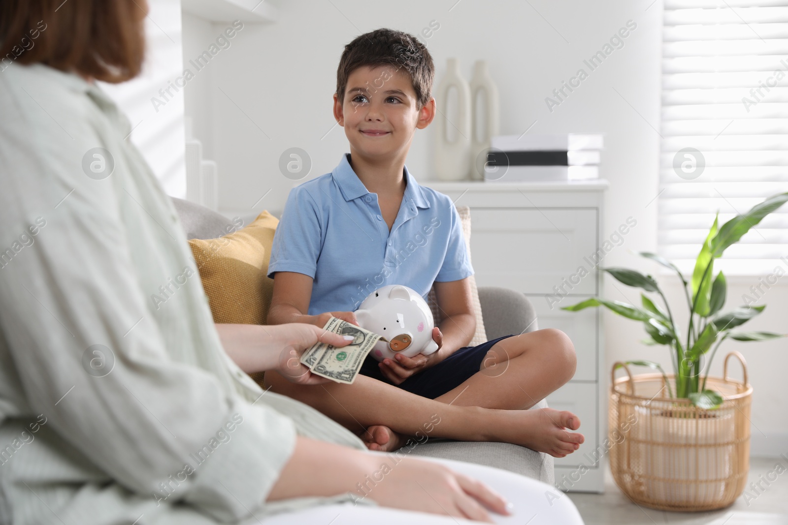 Photo of Mother giving pocket money to her son at home