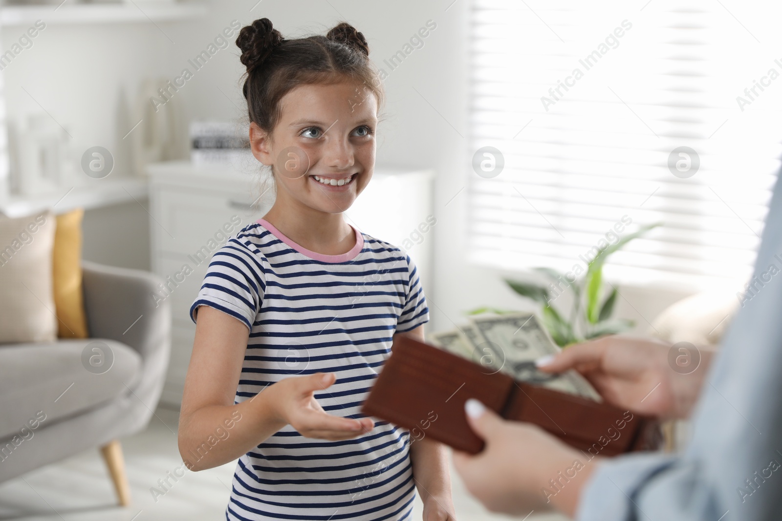 Photo of Mother giving pocket money to her daughter at home