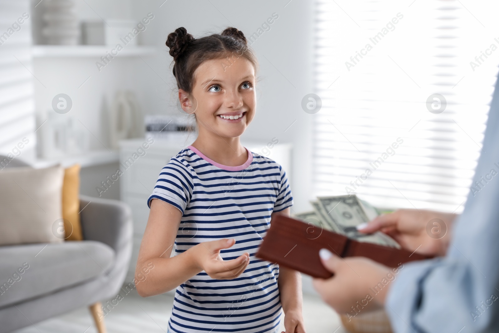 Photo of Mother giving pocket money to her daughter at home