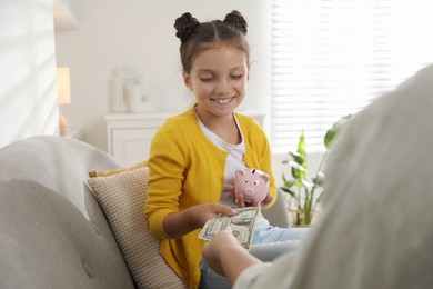 Mother giving pocket money to her daughter at home