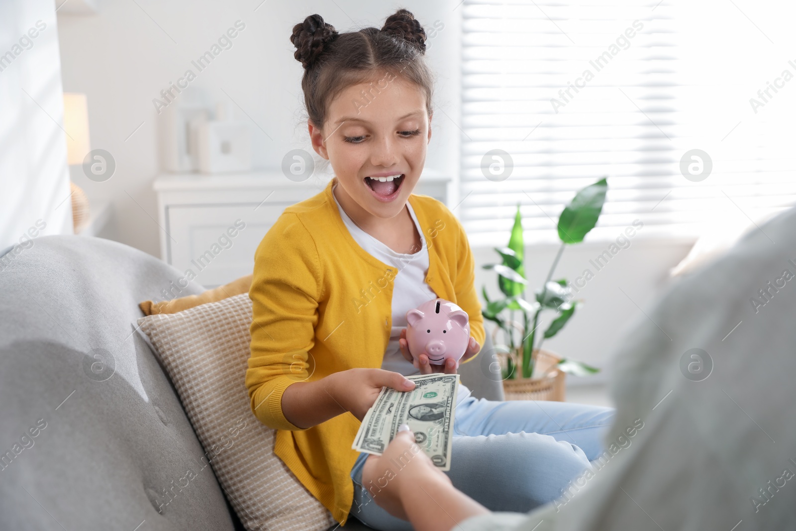 Photo of Mother giving pocket money to her daughter at home