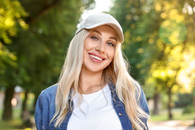 Photo of Portrait of smiling woman in baseball cap outdoors