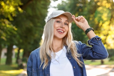 Photo of Portrait of smiling woman in baseball cap outdoors