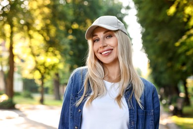 Photo of Portrait of smiling woman in baseball cap outdoors