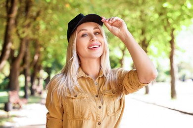 Portrait of smiling woman in baseball cap outdoors