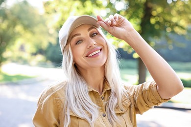 Portrait of smiling woman in baseball cap outdoors