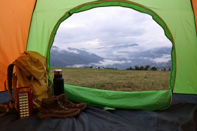 Photo of Picturesque view of mountain from tent with camping equipment