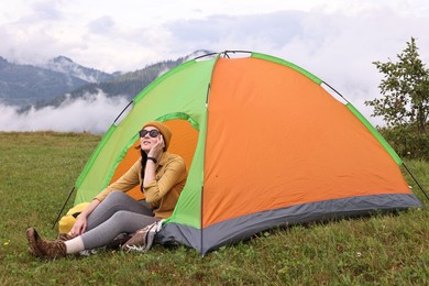 Young camper and tent in mountains. Active tourism