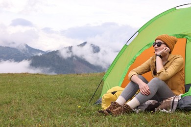 Young camper and tent in mountains. Active tourism