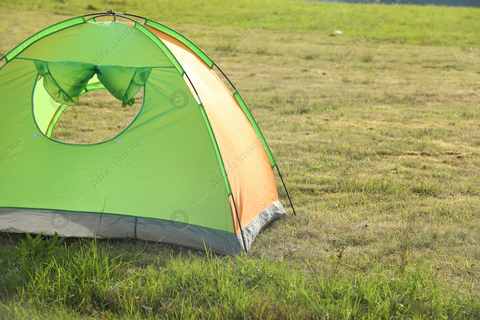 Photo of Tent on green grass in mountains, space for text