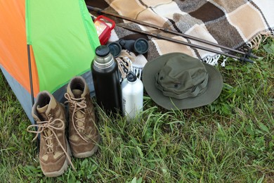 Photo of Tent and camping equipment on green grass outdoors