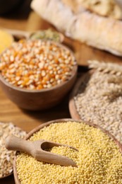 Photo of Different types of cereals on wooden table, closeup