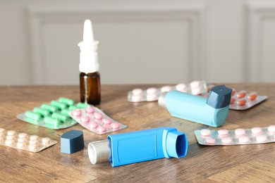 Photo of Different asthma medications on wooden table indoors, closeup