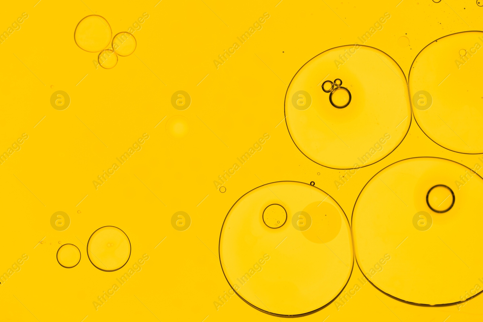 Photo of Sample of cosmetic oil on yellow background, macro view