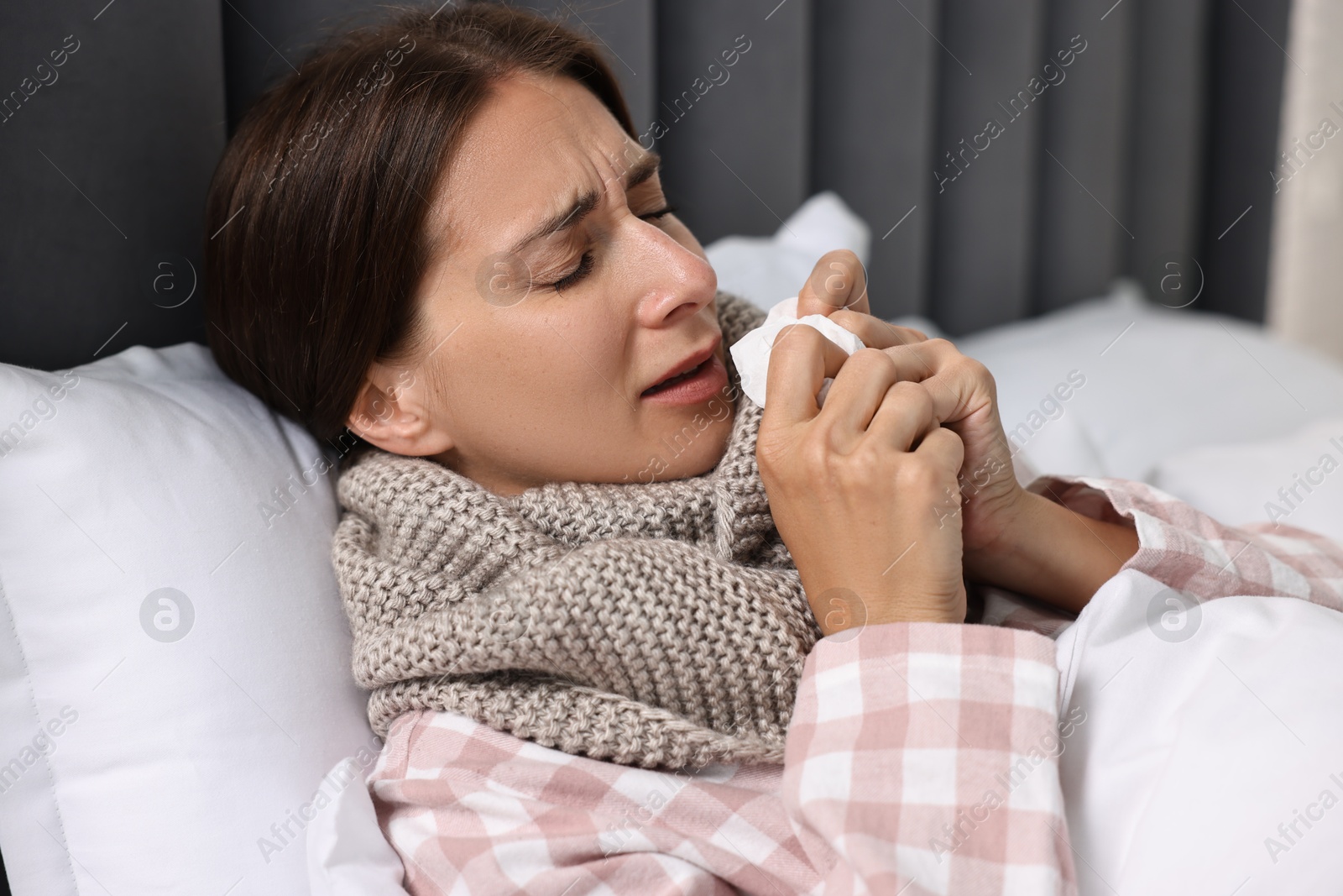 Photo of Sick woman with tissue in bed. Cold symptoms