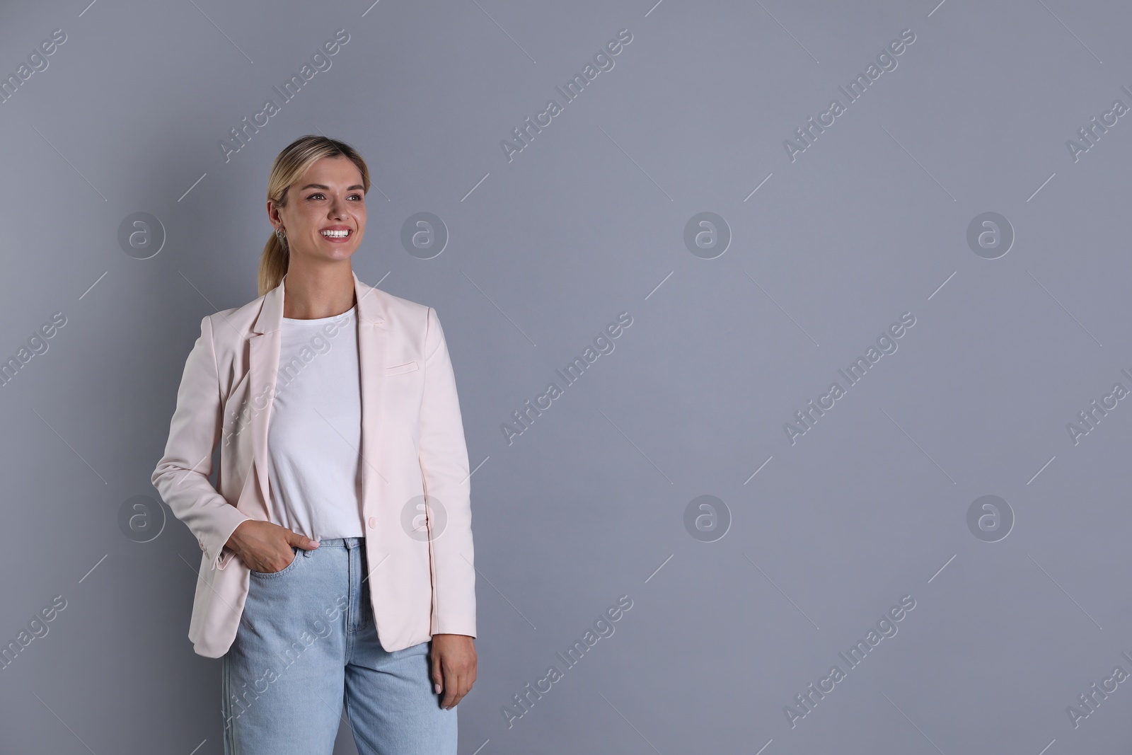 Photo of Beautiful woman in stylish jacket on grey background, space for text