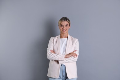 Photo of Beautiful woman in stylish jacket on grey background