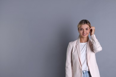 Photo of Beautiful woman in stylish jacket on grey background, space for text