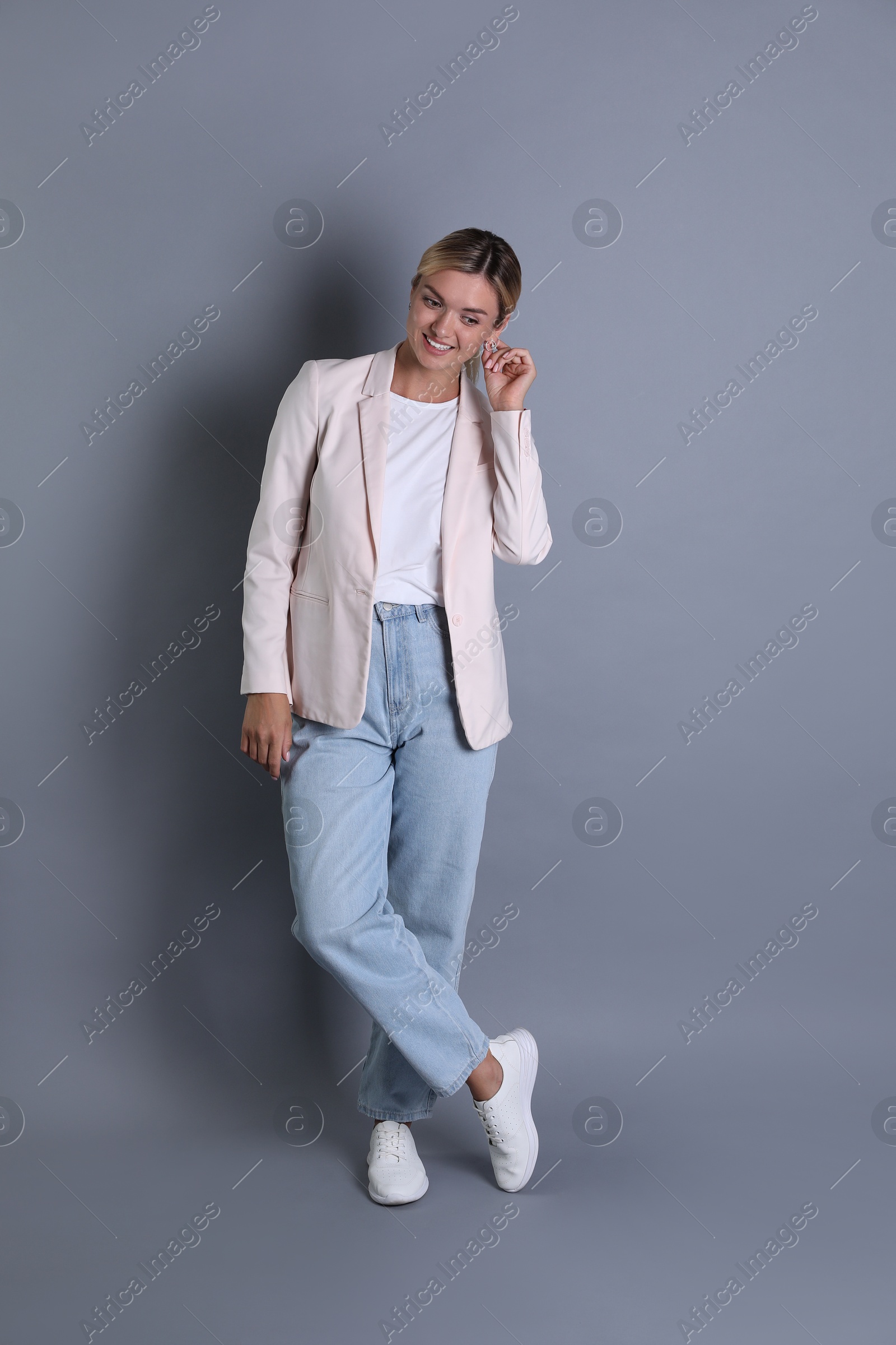 Photo of Beautiful woman in stylish jacket on grey background