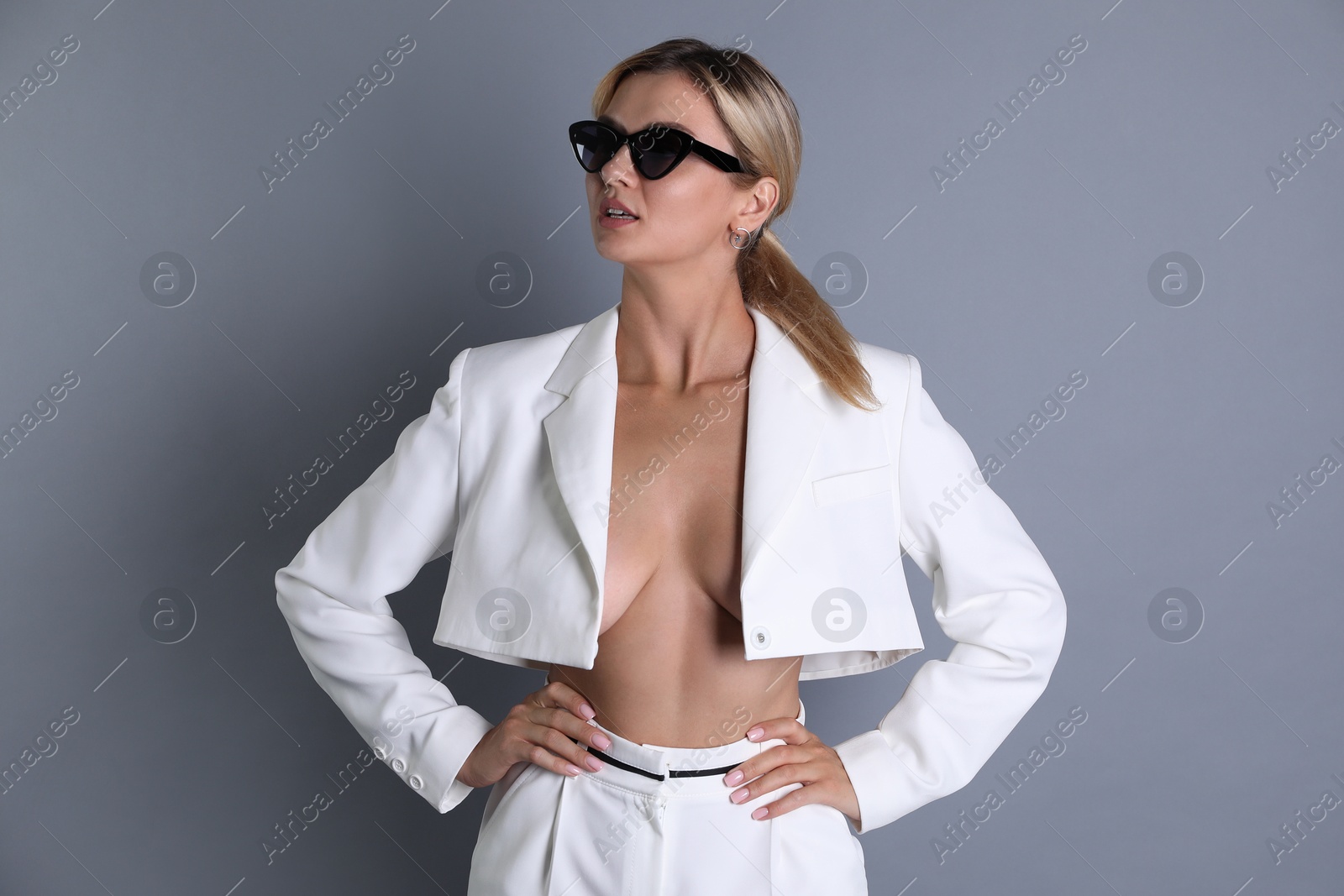 Photo of Beautiful woman in stylish white suit on grey background