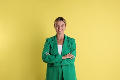 Photo of Beautiful woman in stylish green suit on yellow background