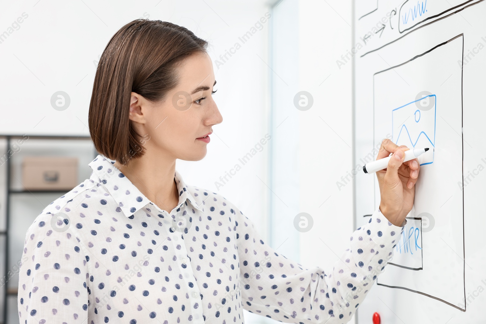 Photo of Developing UI design. Woman drawing website wireframe on whiteboard indoors