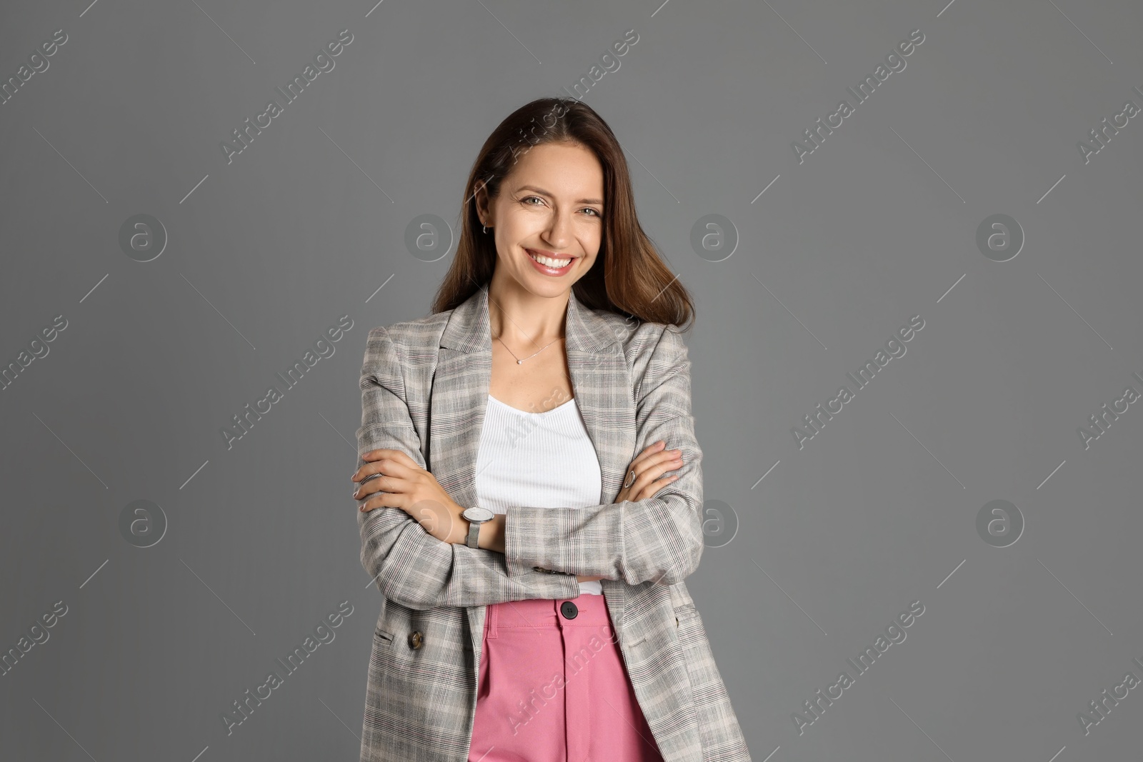 Photo of Beautiful woman in stylish jacket and pink pants on grey background