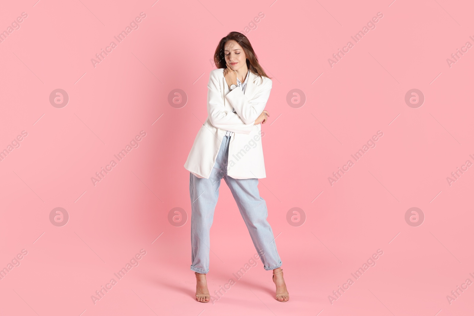 Photo of Beautiful woman in stylish white jacket on pink background