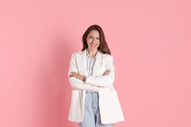 Beautiful woman in stylish white jacket on pink background