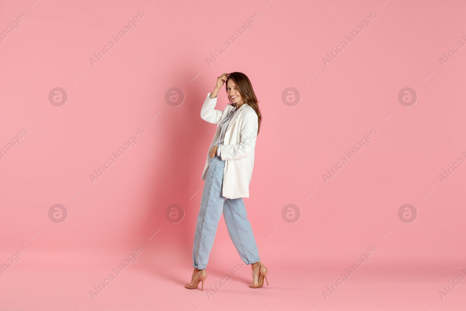 Photo of Beautiful woman in stylish white jacket on pink background