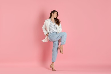 Beautiful woman in stylish white jacket on pink background