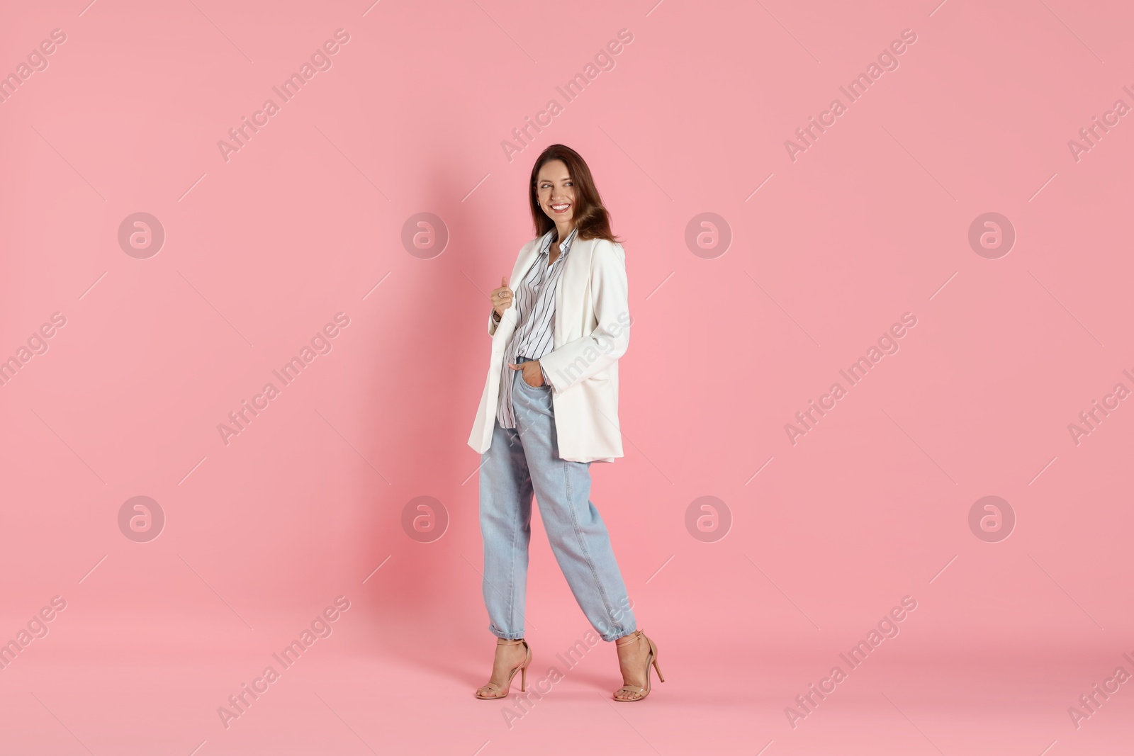 Photo of Beautiful woman in stylish white jacket on pink background