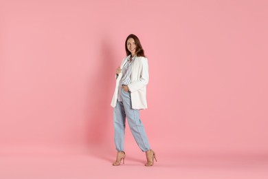 Photo of Beautiful woman in stylish white jacket on pink background