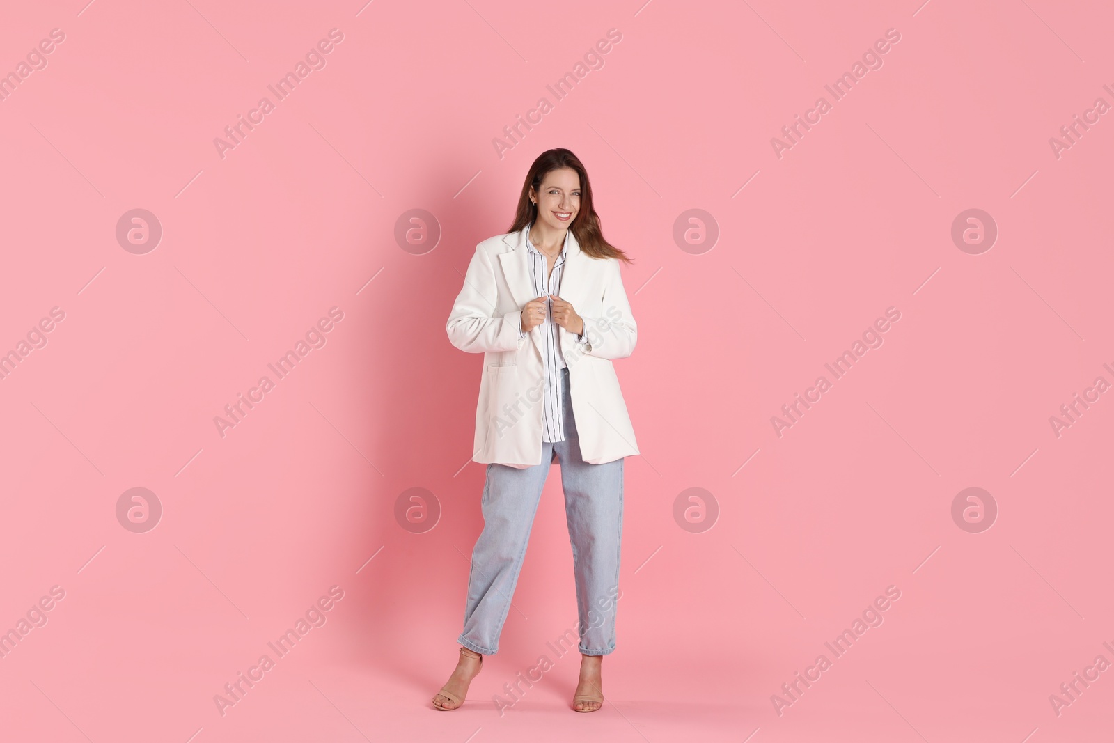 Photo of Beautiful woman in stylish white jacket on pink background