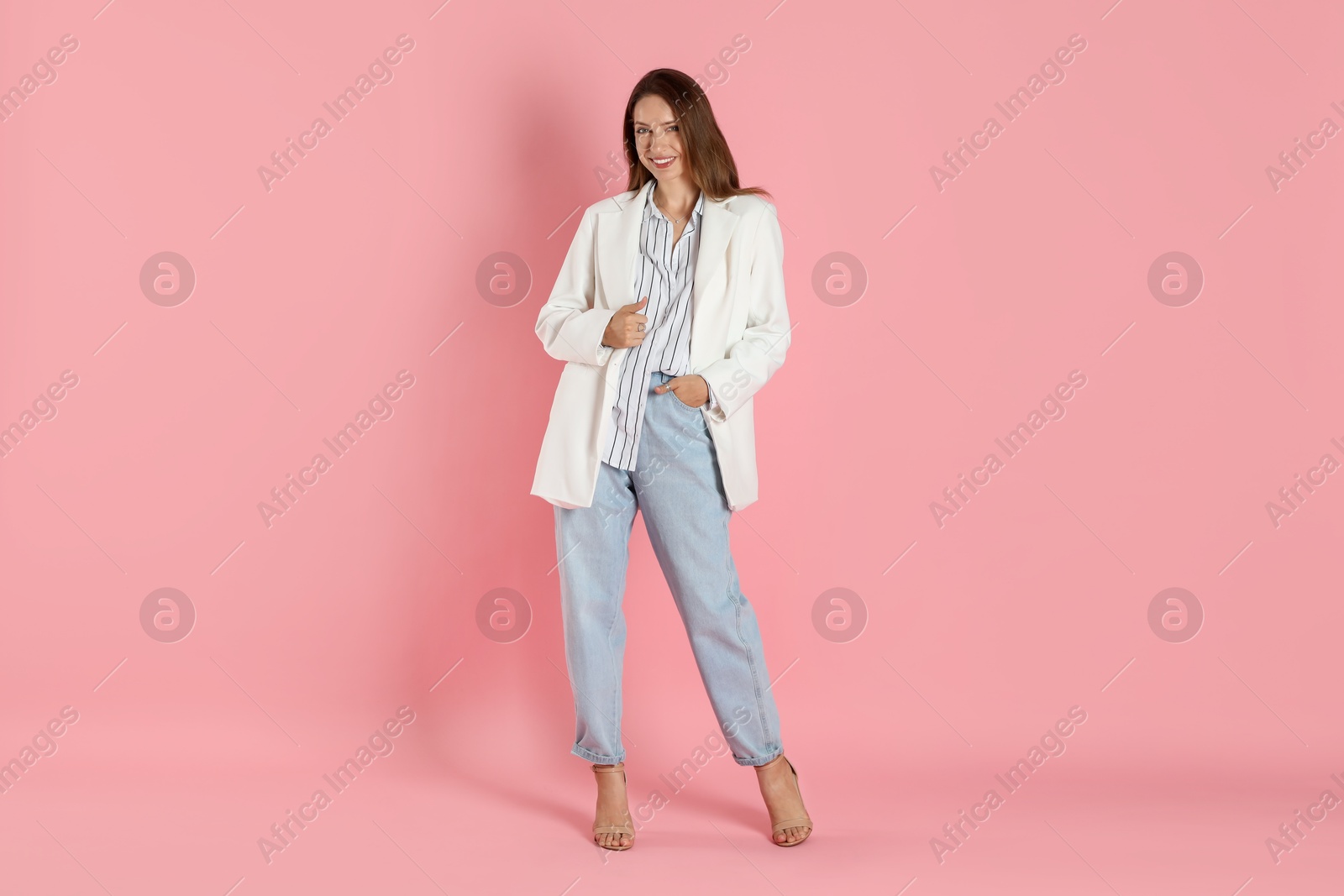 Photo of Beautiful woman in stylish white jacket on pink background