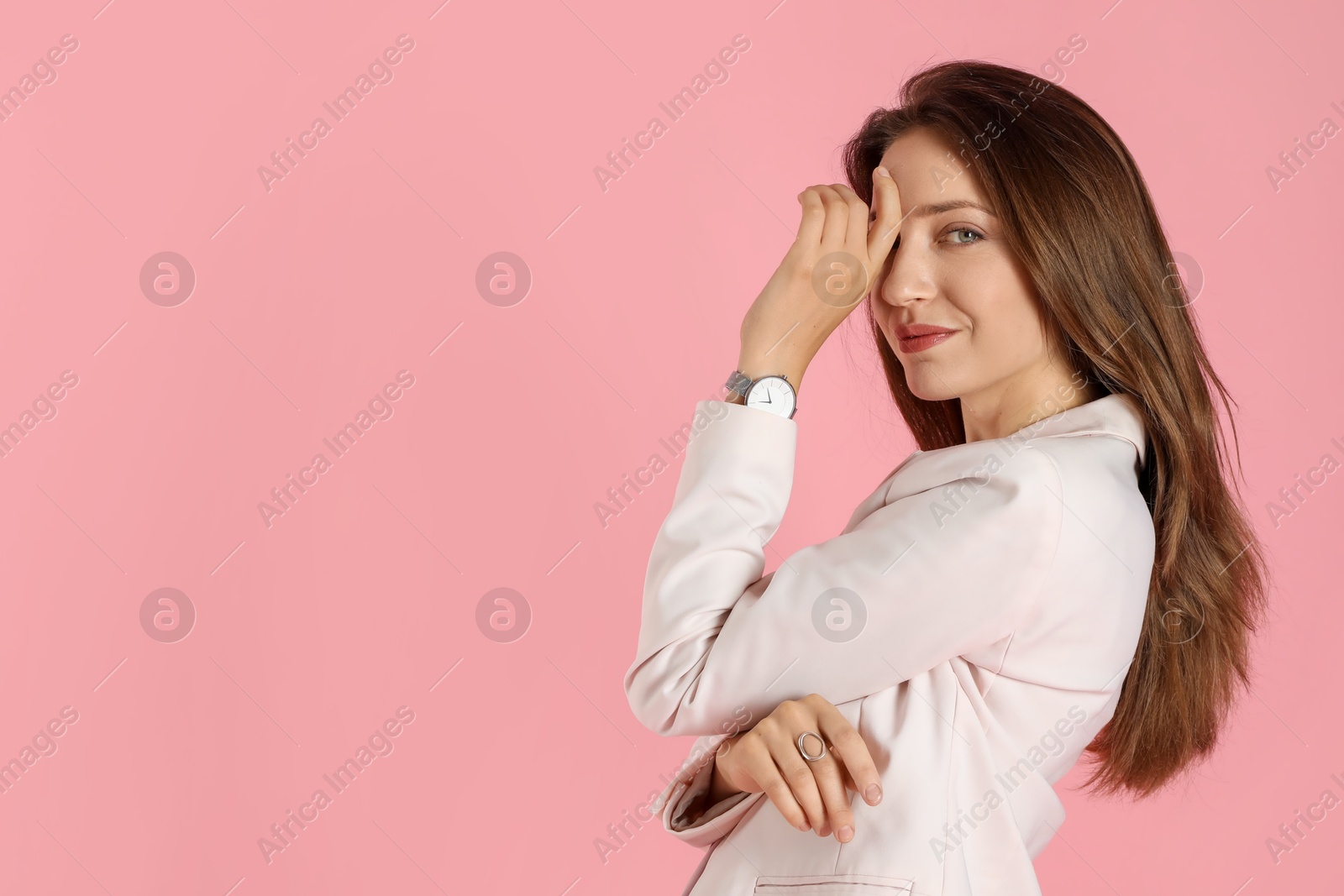 Photo of Beautiful woman in stylish white suit and watch on pink background, space for text