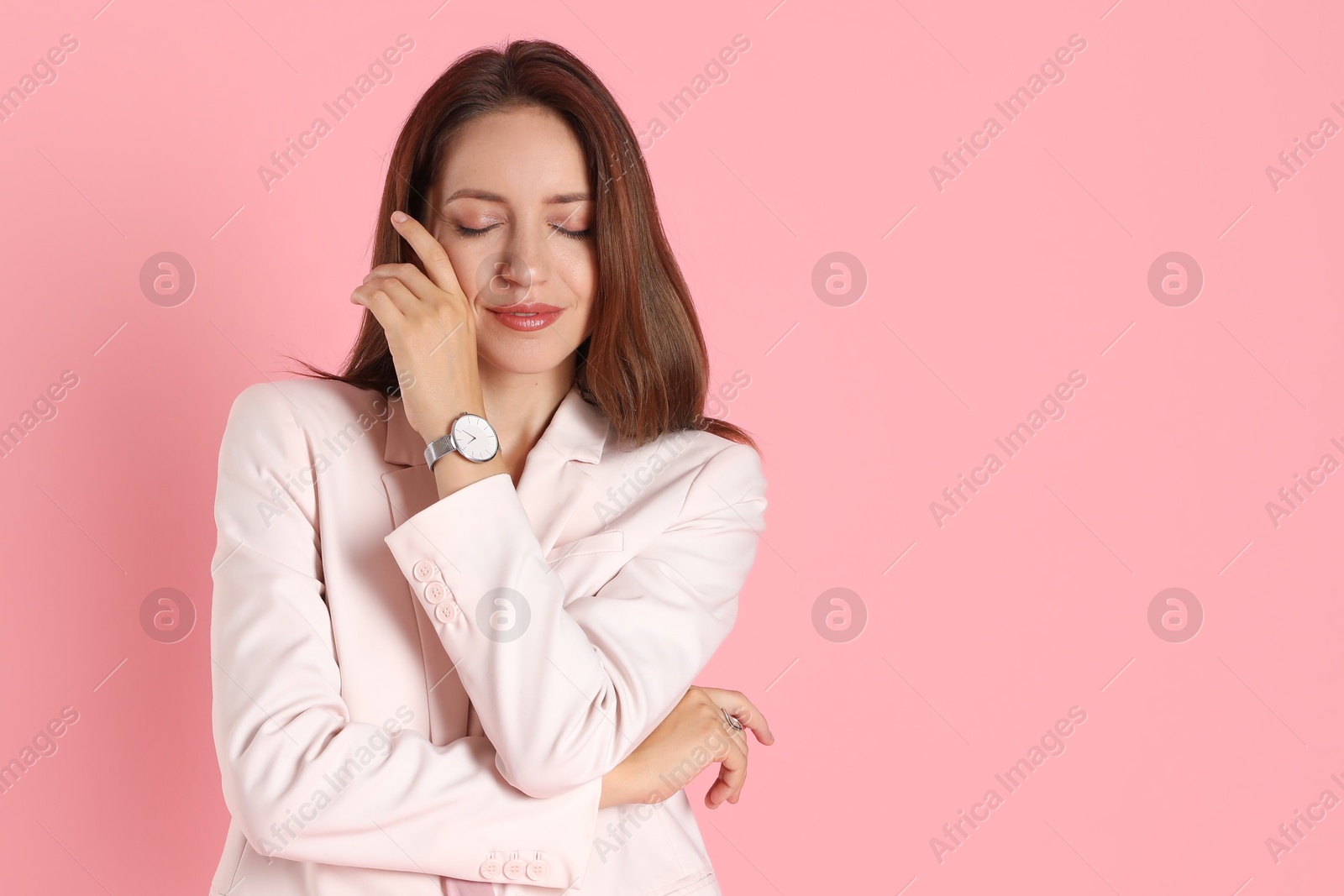 Photo of Beautiful woman in stylish white suit and watch on pink background, space for text