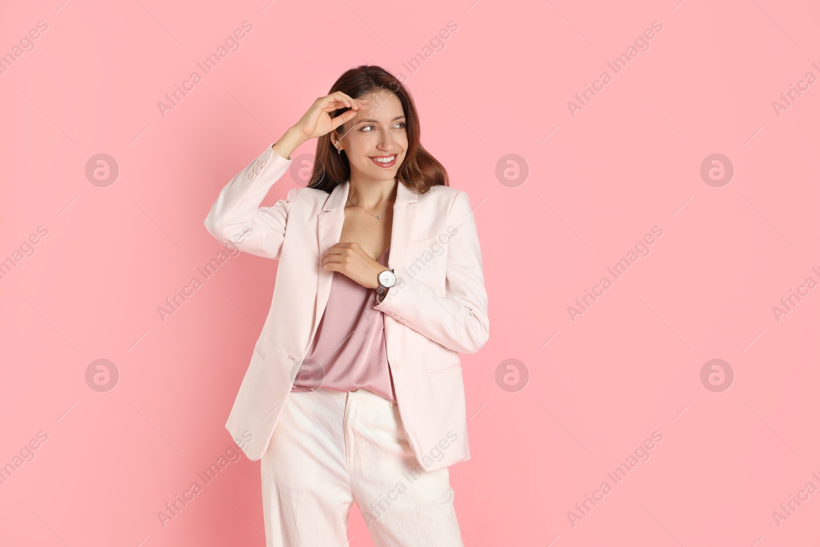 Photo of Beautiful woman in stylish white suit on pink background, space for text