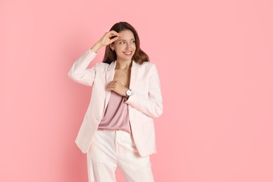 Photo of Beautiful woman in stylish white suit on pink background, space for text