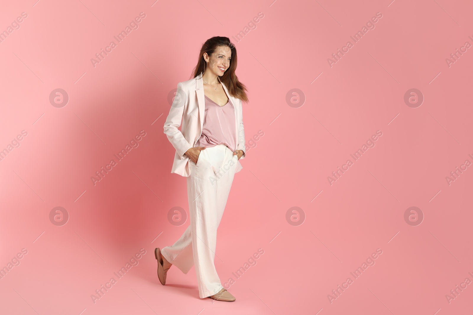 Photo of Beautiful woman in stylish white suit on pink background, space for text