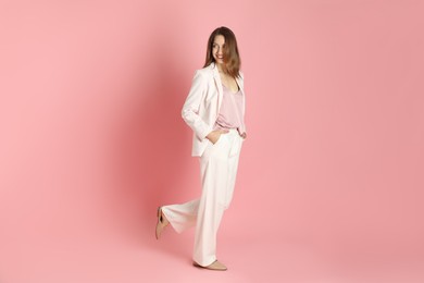 Photo of Beautiful woman in stylish white suit on pink background