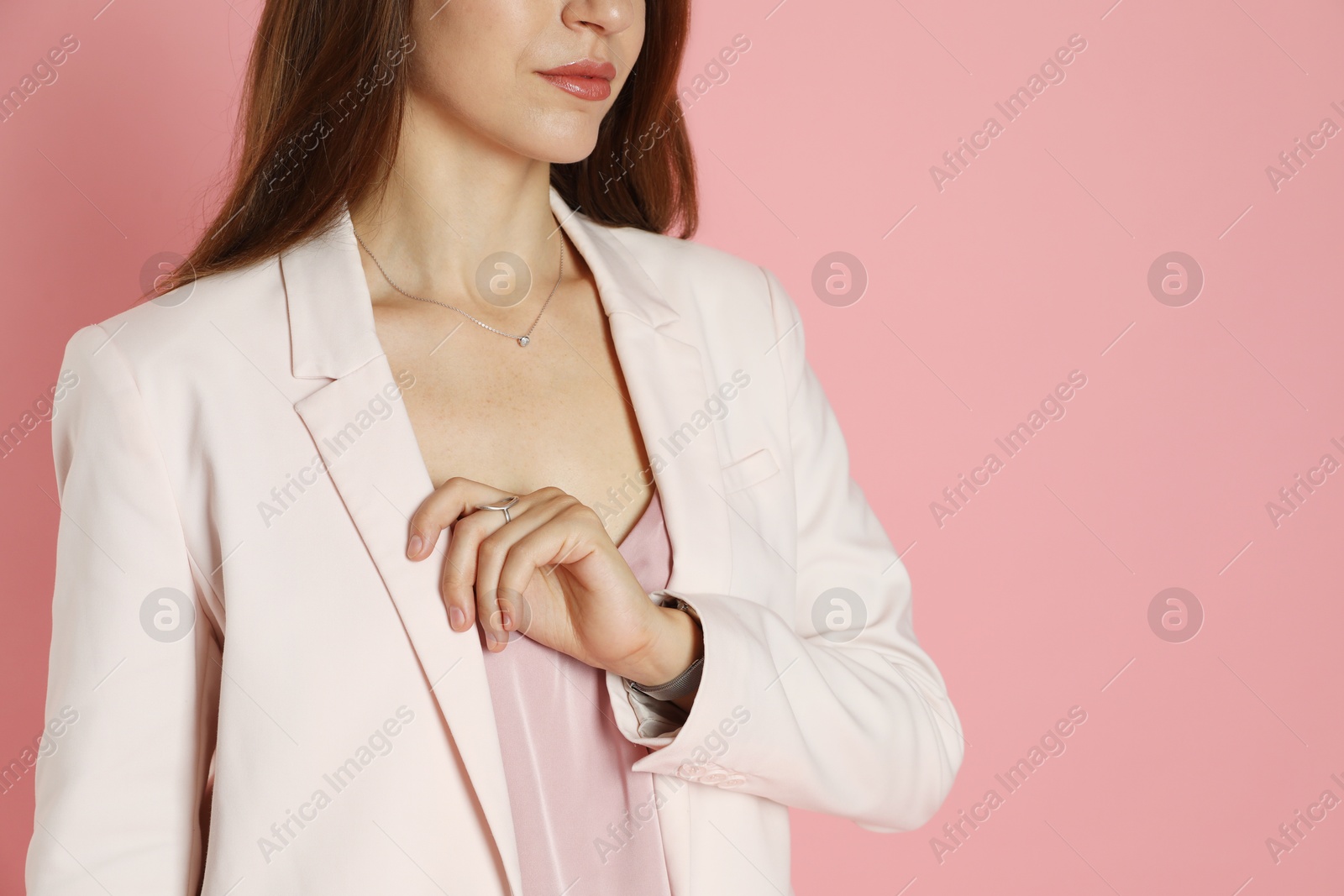 Photo of Beautiful woman in stylish white suit on pink background, closeup. Space for text