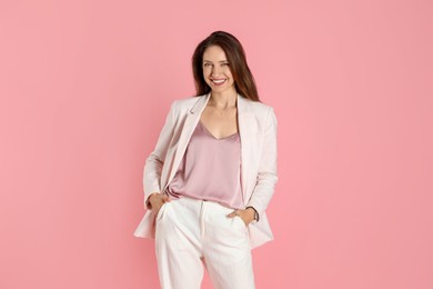 Photo of Beautiful woman in stylish white suit on pink background