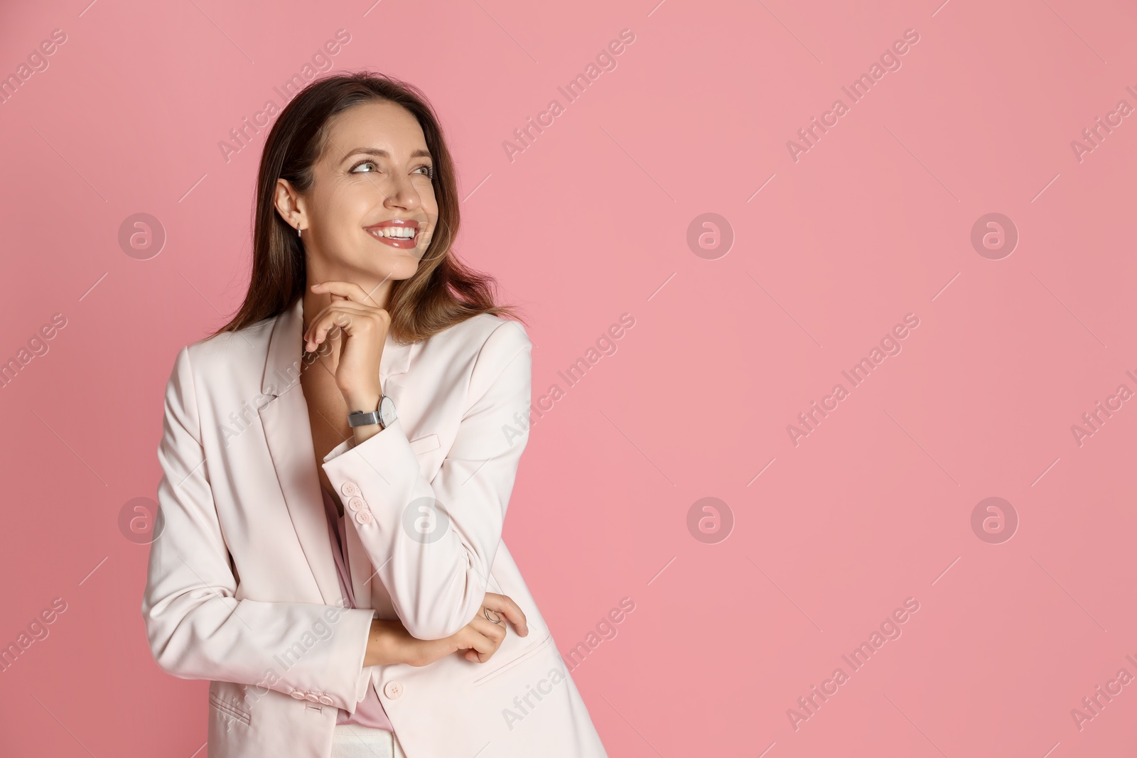 Photo of Beautiful woman in stylish white suit on pink background, space for text