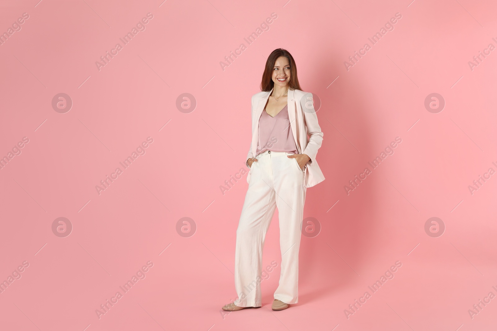 Photo of Beautiful woman in stylish white suit on pink background