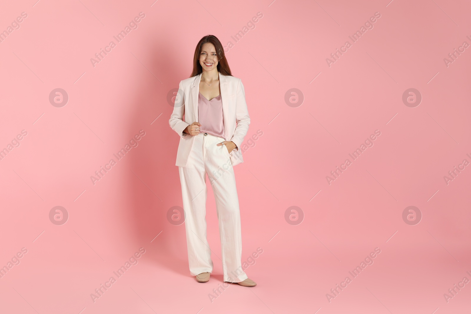 Photo of Beautiful woman in stylish white suit on pink background