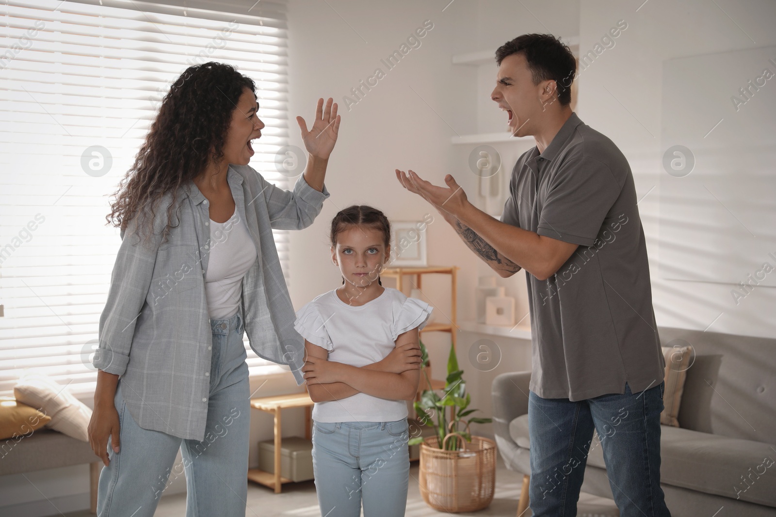 Photo of Divorce concept. Angry couple arguing and their sad daughter at home