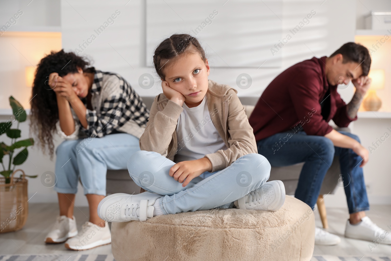 Photo of Divorce concept. Sad couple and their daughter at home